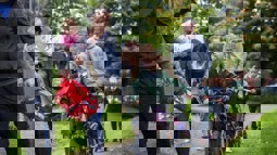 adults and children walking and scooting to school on footpath