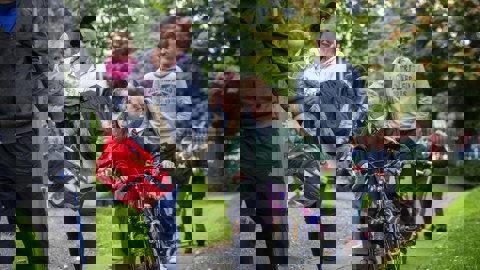 adults and children walking and scooting to school on footpath