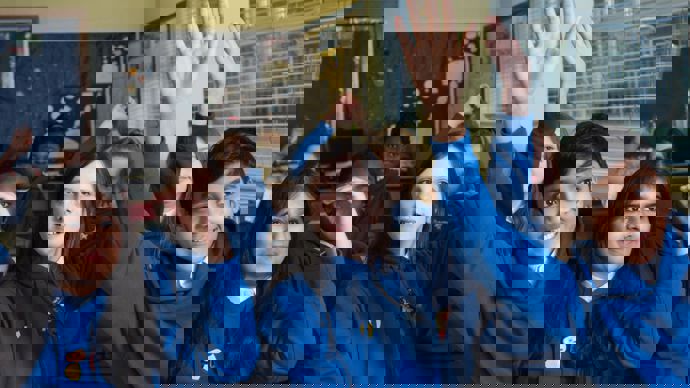 pupils in classroom raising their hands