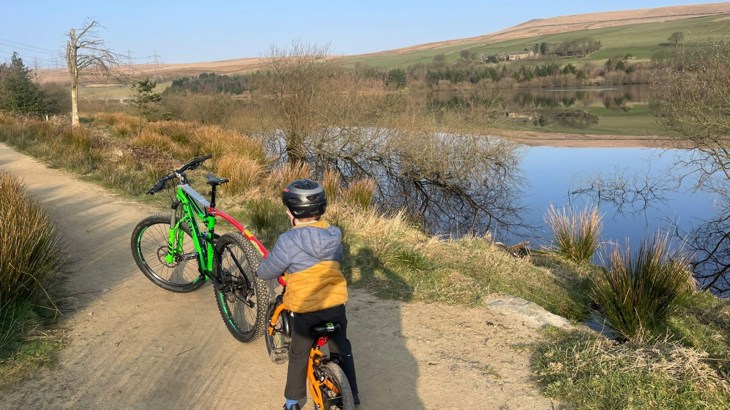 Little boy sat on a tandem bike looking out at countryside views - on his way to school as part of Walk Wheel Cycle Trust Big Walk and Wheel challenge