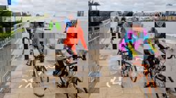 People on bikes cycling over bridge in London