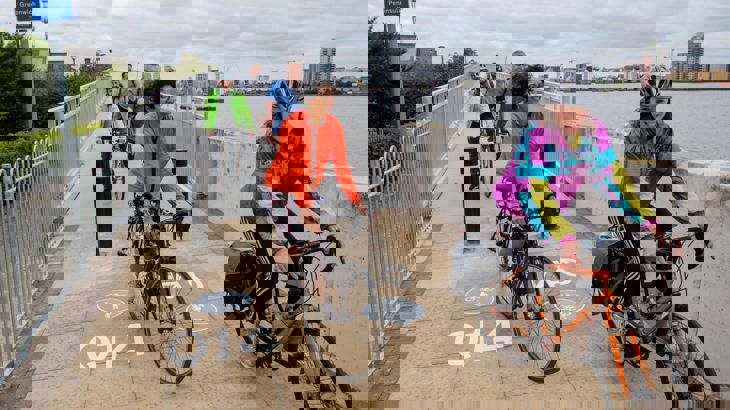 People on bikes cycling over bridge in London