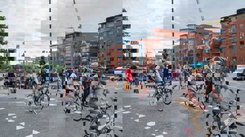 people walking and on bikes using a road crossing in a city