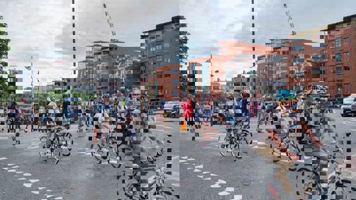 people walking and on bikes using a road crossing in a city