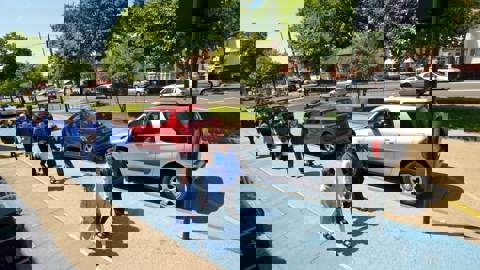 young children in uniform walking to school on a wide path, painted light blue