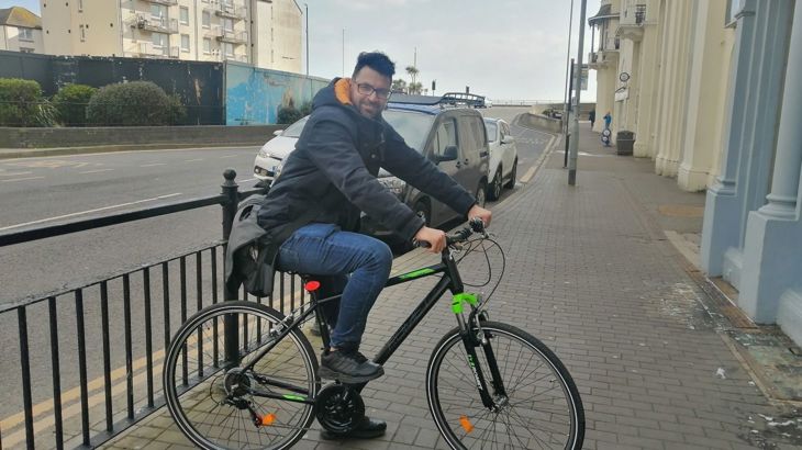 person sat on bike in urban area near seafront