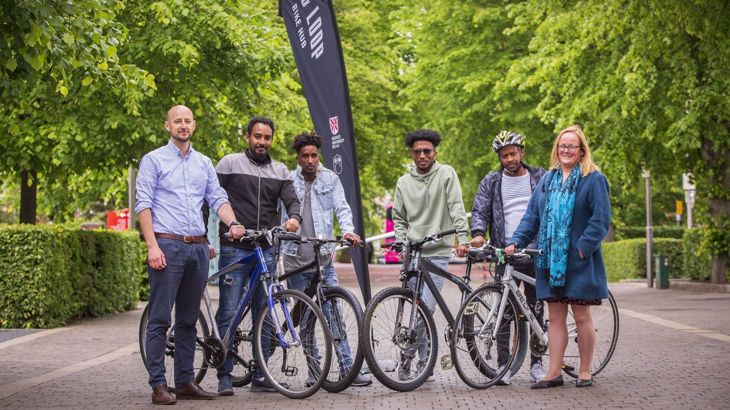 Refugees and project officers with bikes at Botanic Gardens, Belfast