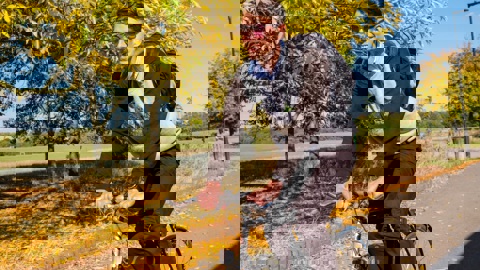 A young man cycles along a cycle route on a sunny autumnal day 