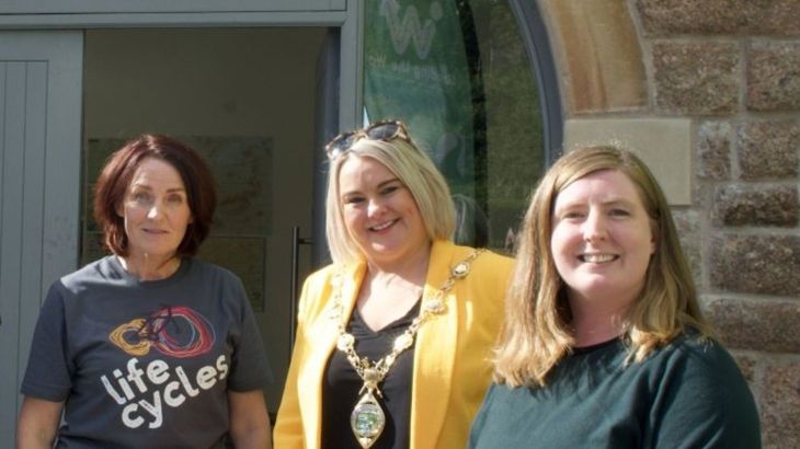 Three women standing outside, one is wearing a gold Mayor's chain.