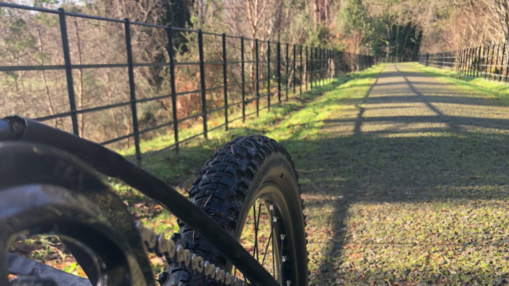Point of view from an XCR handcycle, looking down a tree lined traffic-free path on the National Cycle Network on a sunny autumn day.