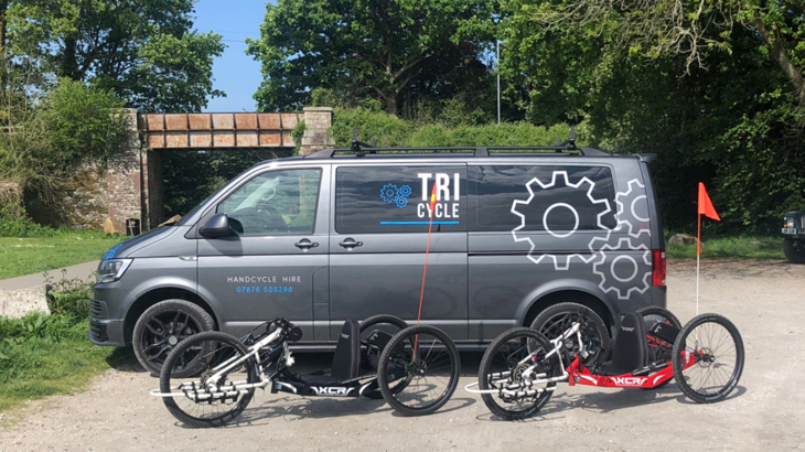 Laura's branded TRI-cycle van with her two XCR handcycles in a car park beside the Camel Trail.
