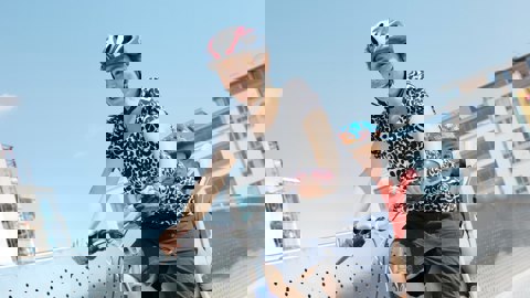 Mum cycling with child in bike seat behind her