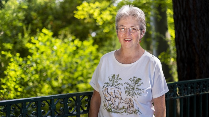 Noelle O'Neill is pictured in front of a railing with trees in the background.