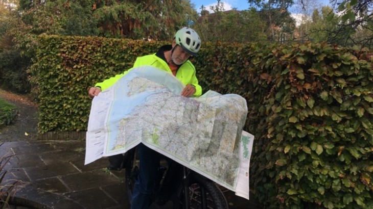 Norman Feakins, an e-bike rider in his 70s, looking at his map of the National Cycle Network.