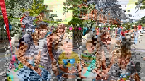 Families drawing on the street of a street party closure