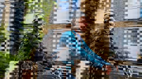 Woman cycling on residential street wearing helmet and backpack 