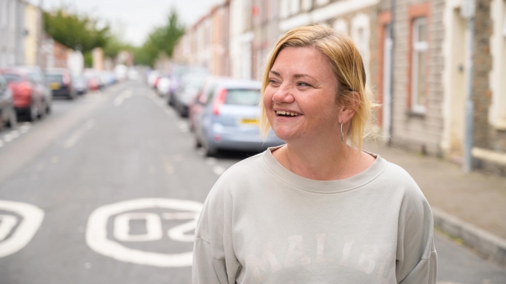 A woman smiling on a residential street where 20mph is already the default speed limit.
Menyw yn gwenu ar stryd preswyl sydd eisoes â therfyn 20mya.