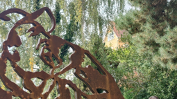 Close up of steel portrait of John Garard wearing a cap. Trees line the background.