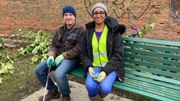 Two ~Walk Wheel Cycle Trust volunteers sitting on a bench smiling.