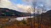 Landscape image of loch with tree-covered hillsides.