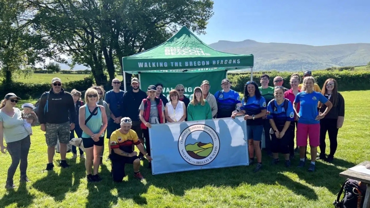 Group of adults posing for a group photo on a sunny day promoting the walking group, Walking the Brecon Beacons.
