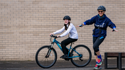 A woman leading a cycling session and a teenage girl on a bike