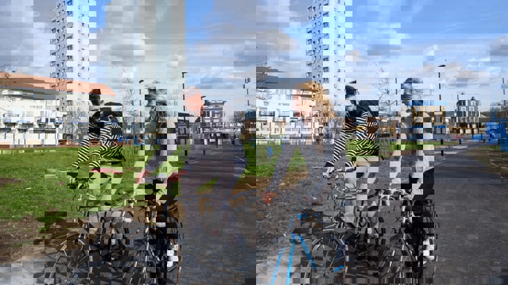 Two colleagues cycling along a path side-by-side when commuting to work