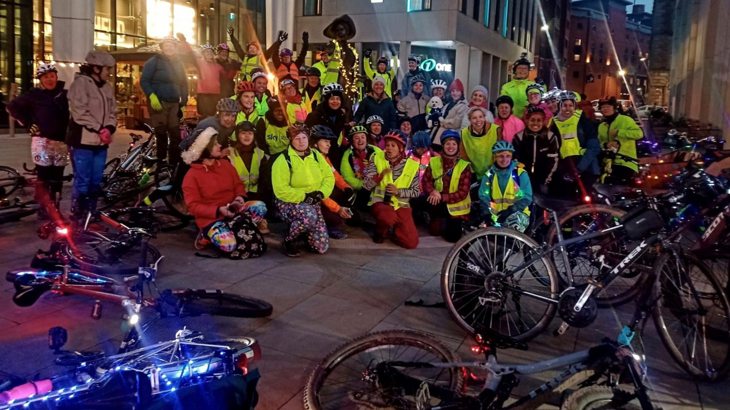 A group of women attending the Lights Up Ride in Manchester, and posing at the statue of suffragette Emmeline Pankhurst in St Peter's Square.