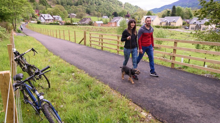 Male and female cyclist with dog on Loch Earn Railway Path (LERP) in Perth and Kinross, linking the villages of Comrie, St Fillans and Lochearnhead.