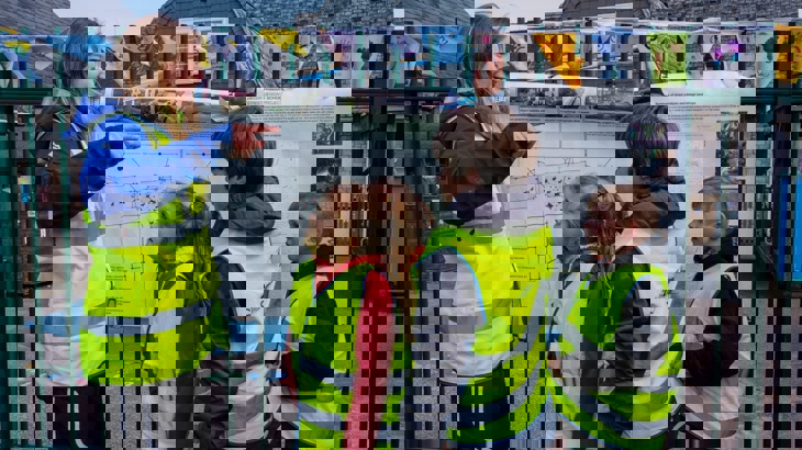 Walk Wheel Cycle Trust project officer looking at a school street plan with children