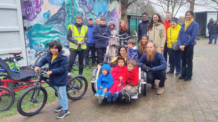 Group of people with bikes standing outside the hub.