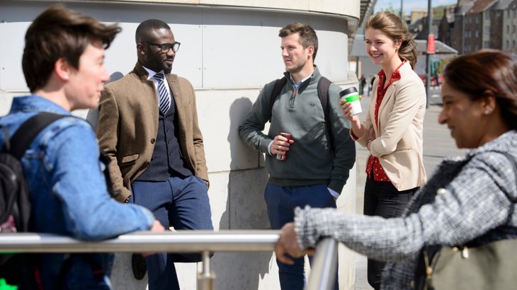 a group of people talking outside an office