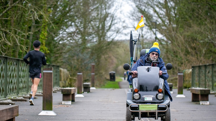 man on a mobility scooter on a path