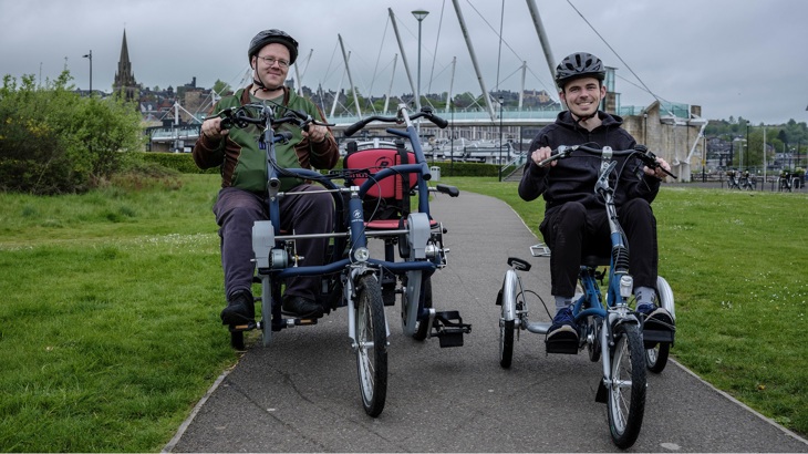 Two people are shown using adapted bicycles in Stirling city centre