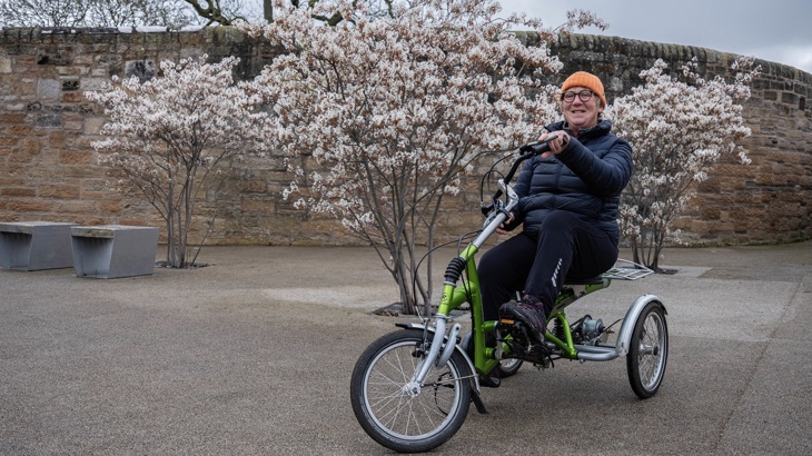 A person is shown riding an adapted cycle