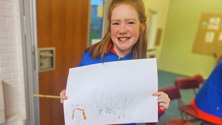 A Guide holding up their poster from the Active Adventures badge launch.