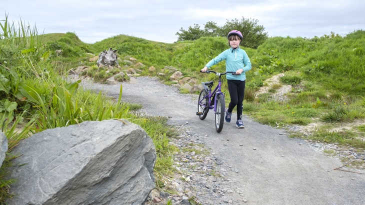 Young person cycling through Arcadia park