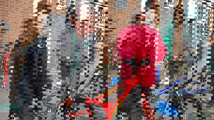 schoolboy cleaning bicycle with brush