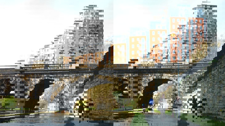 Walkers next to a canal on the Aire Valley Towpath