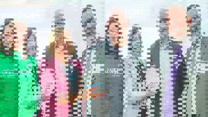 Award presentation with four people posing with the award