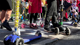 A group of children on decorated scooters, ready to start scooting to school.