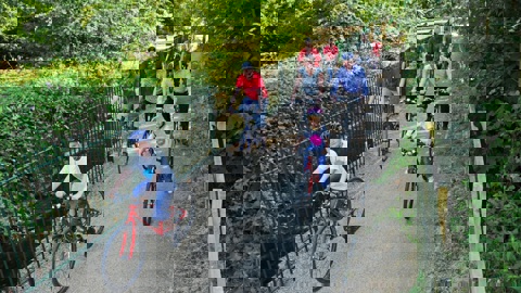 adults and children cycling on bridge