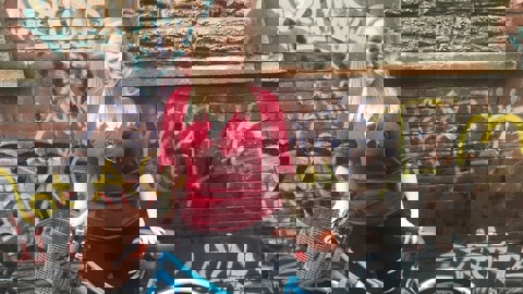 Gwyneth poses with her bike in front of a wall