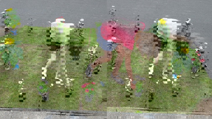 A Young Girl Plants Some Flowers On Embleton Road