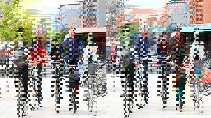 Officials from Walk Wheel Cycle Trust and the government ride the bikes through the centre of Belfast