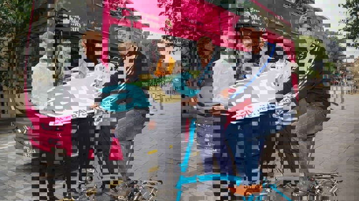 People celebrating the Active Travel Challenge in front of a bus in Belfast