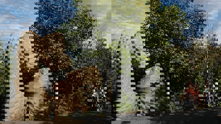 Stone drinking fountain sculpture in shape of Roman centurion with bottle