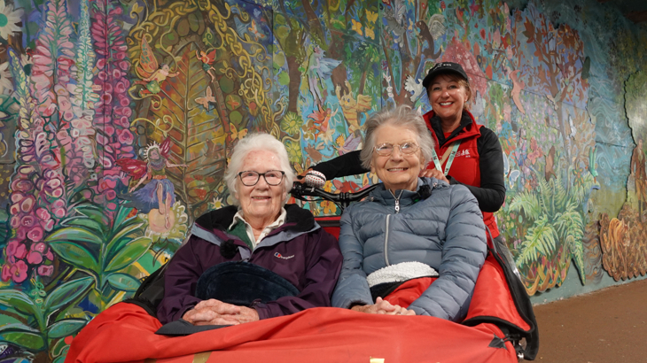 A trishaw with passengers in front of the stunning art mural in Alloway Railway Tunnel.