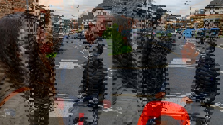 A group of people chatting and smiling in a residential area of London