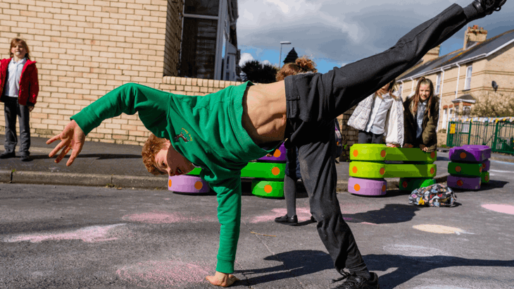School boy cartwheeling in street